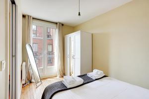 1 dormitorio con cama y ventana grande en Pick A Flat's Apartment in Saint-Ouen - Rue des Rosiers, en Saint-Ouen