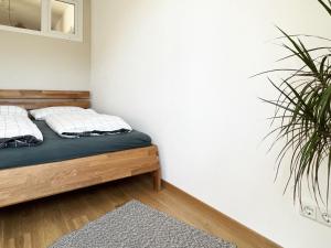 1 dormitorio con cama y planta en Moderne CityWohnung nahe Theresienwiese & Westpark, en Múnich