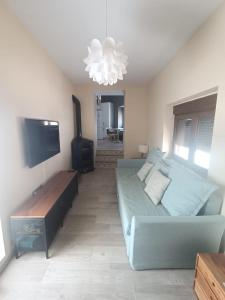 a living room with a couch and a flat screen tv at Un encanto en el corazón de Vejer con terraza privada in Vejer de la Frontera