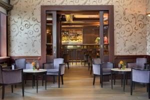 a restaurant with tables and chairs and a bar at Splendid Etoile in Paris