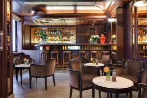 a restaurant with tables and chairs and a bar at Splendid Etoile in Paris +33 photos