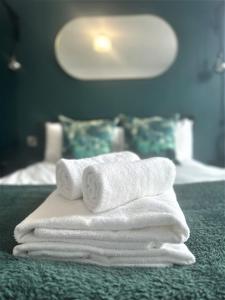 a pile of towels sitting on top of a bed at Harbourside Hideaway - Superb Flat with Terrace in Bristol