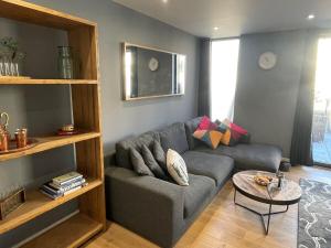 a living room with a gray couch and a table at Harbourside Hideaway - Superb Flat with Terrace in Bristol