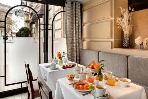 a dining room with two tables with food on them at Splendid Etoile in Paris