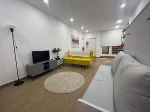 sala de estar con sofá amarillo y TV en Estudio en Palacio La Latina, en Madrid