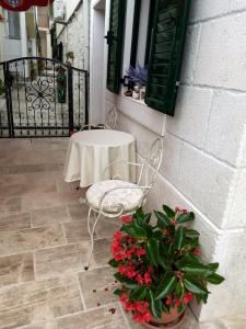 a table and a chair and flowers on a patio at Apartment Nina in Promajna