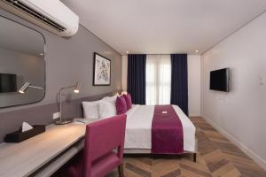 um quarto de hotel com uma cama e uma secretária em The Belamy House Managed by HII em Manila