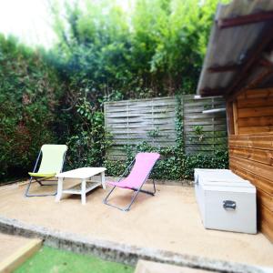 2 sillas y una mesa en el patio en NOUVEAUTE 2023 Maison Cocooning avec jardin, Terrasse couverte et Jacuzzi en Bellerive-sur-Allier