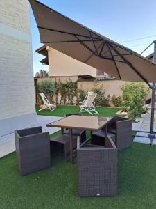 a picnic table and chairs under a large umbrella at Casa Nonna Lina in Sommariva del Bosco