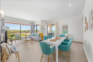 a living room with a white table and chairs at Seaview Serenity with Pool & Garden in Quarteira