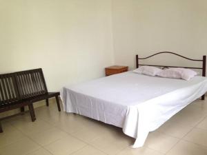 a bedroom with a white bed and a bench at Vegan Stay by The Vegan Kitchen by Sulo in Boralesgamuwa +7 photos