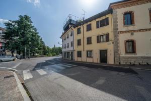 una calle vacía con un edificio a un lado de la carretera en Residenza alle Grazie, en Udine