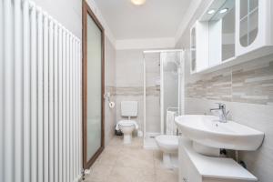 Baño blanco con lavabo y aseo en Residenza alle Grazie, en Udine