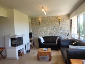 una sala de estar con 2 sofás de cuero y una pared de piedra. en Casa Acqua Dolce - House with 4 Bedrooms and Own Spa, en Oprtalj