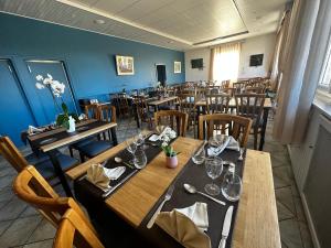 une salle à manger avec des tables et des chaises en bois dans l'établissement Logis Relais des Monedieres, à Seilhac