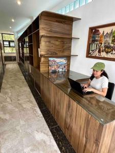a woman sitting at a counter with a laptop at The French Villa -Santander in Santander