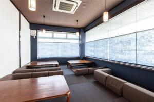 una sala d'attesa con sedie, tavoli e finestre di Global Resort Misen - グローバルリゾート弥山 a Hatsukaichi