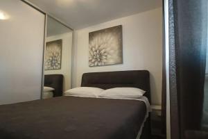 a bedroom with a bed and a mirror at Apartmani Srdarović 3 in Drage