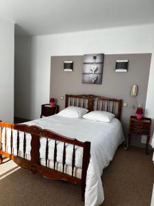 1 dormitorio con 1 cama grande con sábanas blancas en Logis Relais des Monedieres en Seilhac