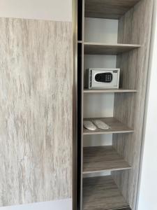 a closet with a microwave on a shelf at General guesthouse in Yerevan