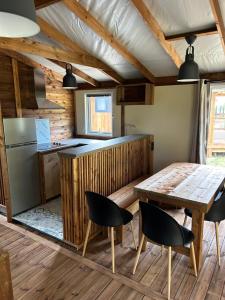a kitchen with a table and chairs in a room at Camping de la Plage in Marck