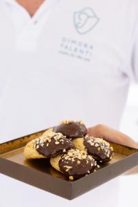 a person holding a box of chocolate dipped cookies at Dimora Talenti in Polignano a Mare