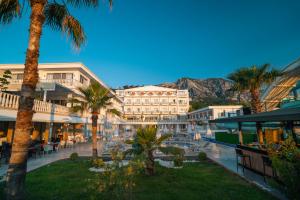 a resort with palm trees and a mountain in the background at SL La Perla Hotel Kemer in Antalya