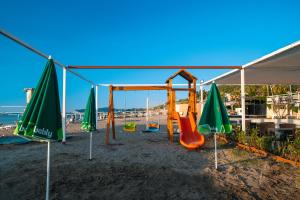 a swing set on the beach with umbrellas at SL La Perla Hotel Kemer in Antalya