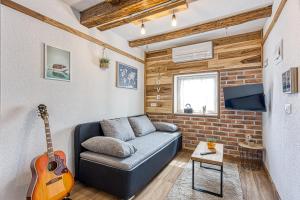 a living room with a couch and a guitar at Holiday Home Carpe Diem in Jastrebarsko