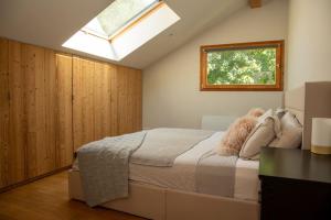Schlafzimmer mit einem großen Bett und einem Dachfenster in der Unterkunft Family Chalet 3 Bedrooms + Sauna + Mountain Views in Les Houches