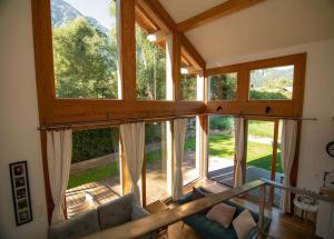 ein Wohnzimmer mit großen Fenstern und einem Sofa in der Unterkunft Family Chalet 3 Bedrooms + Sauna + Mountain Views in Les Houches