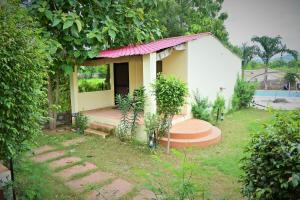 uma pequena casa com alpendre em redor num quintal em Ranthambore Jungle Home em Khilchīpur