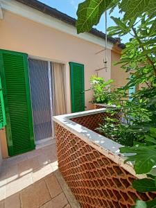 una casa con persianas verdes y una pared de ladrillo en SE019 Senigallia, delizioso cielo-terra con portico, en Senigallia