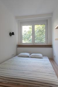 een slaapkamer met een groot bed en 2 ramen bij Angelo S in Belgrado