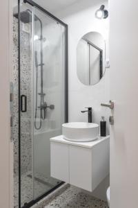 een witte badkamer met een wastafel en een douche bij Angelo S in Belgrado