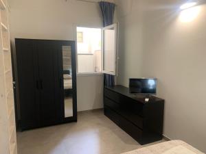 レッチェにあるCASAFRANCYのテレビ、ドレッサー、窓が備わる客室です。