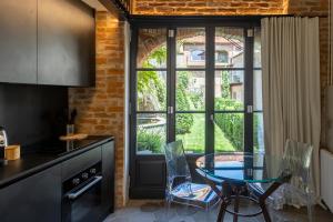 a kitchen with a table and chairs next to a window at Palazzo Fauzone Relais in Mondovì