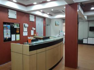 un vestíbulo de oficina con barra y paredes rojas en Bintang Square Hotel en Kubang Kerian