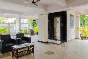 a lobby with two chairs and a table and a door at Itsy By Treebo - Opal Suites in Pune