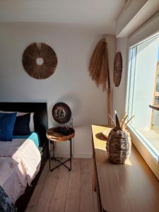 Schlafzimmer mit einem Bett, einem Tisch und einem Fenster in der Unterkunft Appartement au Grau du roi in Le Grau-du-Roi