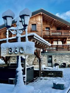 Chez L'Angèle في لي جيه: منزل مغطى بالثلج مع عمود خفيف