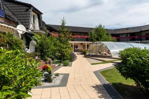 a garden with a greenhouse next to a building at Perła Bałtyku in Pustkowo