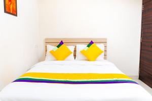 a bedroom with a white bed with colorful pillows at Itsy By Treebo - Opal Suites in Pune