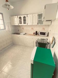 eine Küche mit weißen Schränken und einer grünen Theke in der Unterkunft Apartamento Siomaly - Piscina in Praia