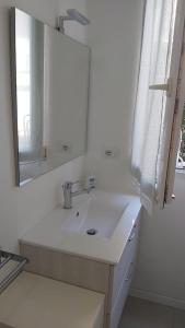 Baño blanco con lavabo y espejo en Casa Le Cementine en Verbania