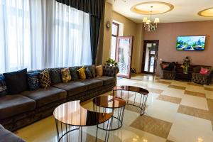 a living room with a couch and two tables at Hotel Stefani in Sibiu
