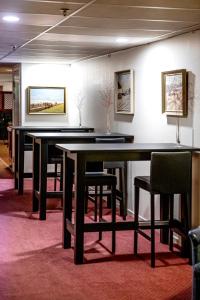 a ping pong table and chairs in a room at Hotel Kupolen in Borlänge