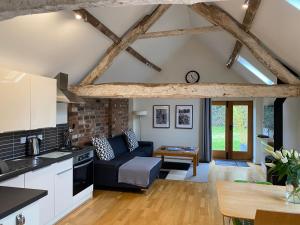 eine Küche und ein Wohnzimmer mit freiliegenden Holzbalken in der Unterkunft Hidden cottages in Henley in Arden