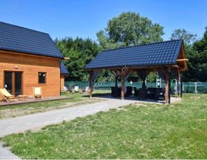 a wooden pavilion in a park next to a building at Amara Houses in Rewal