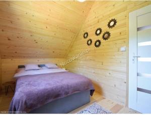 a bedroom with a bed in a wooden cabin at Amara Houses in Rewal
